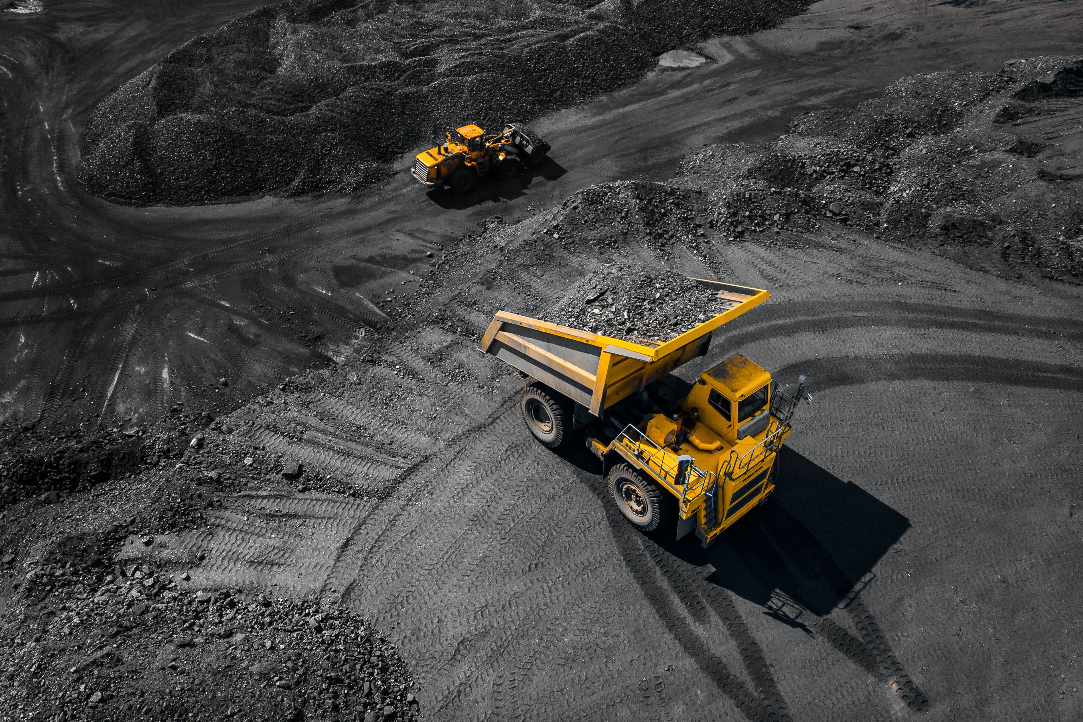 Aerial view of dump trucks at an open pit coal mine.