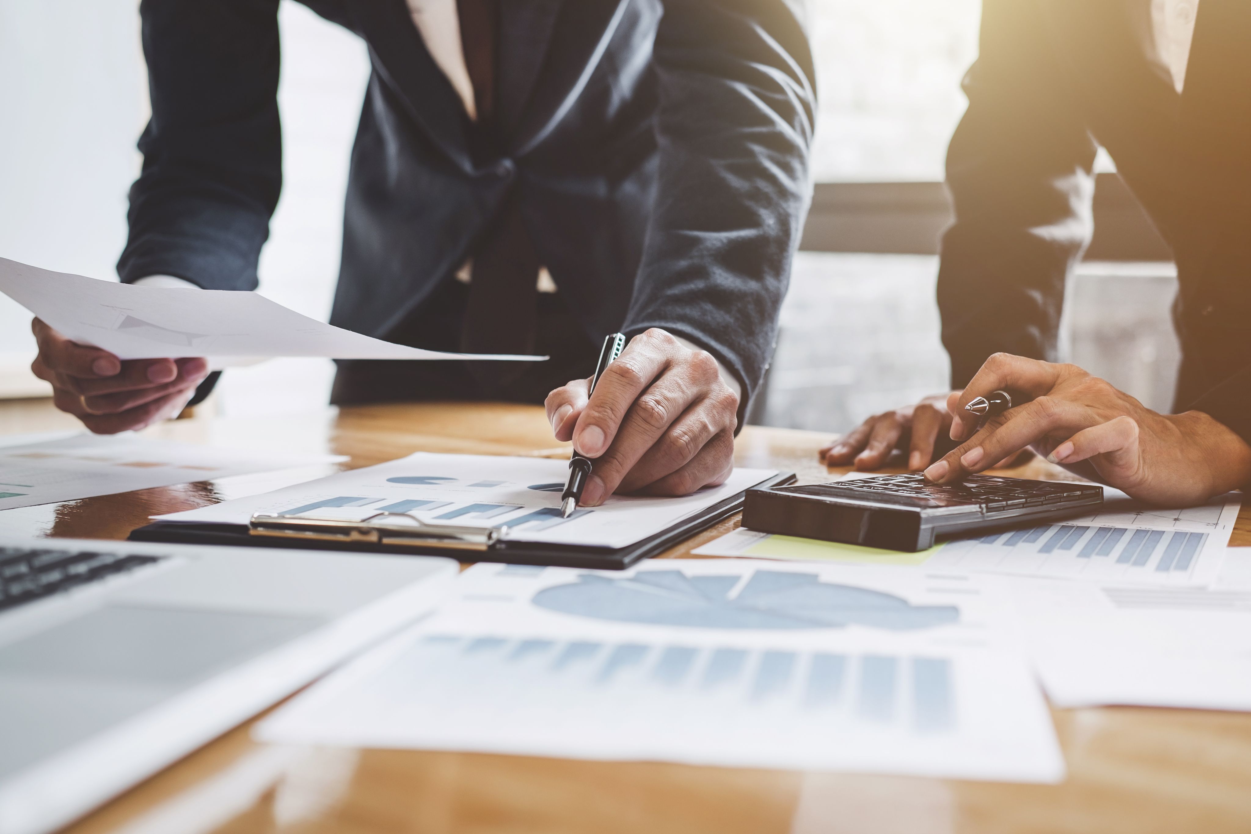 Business team meeting with investor colleagues consulting financial growth charts.