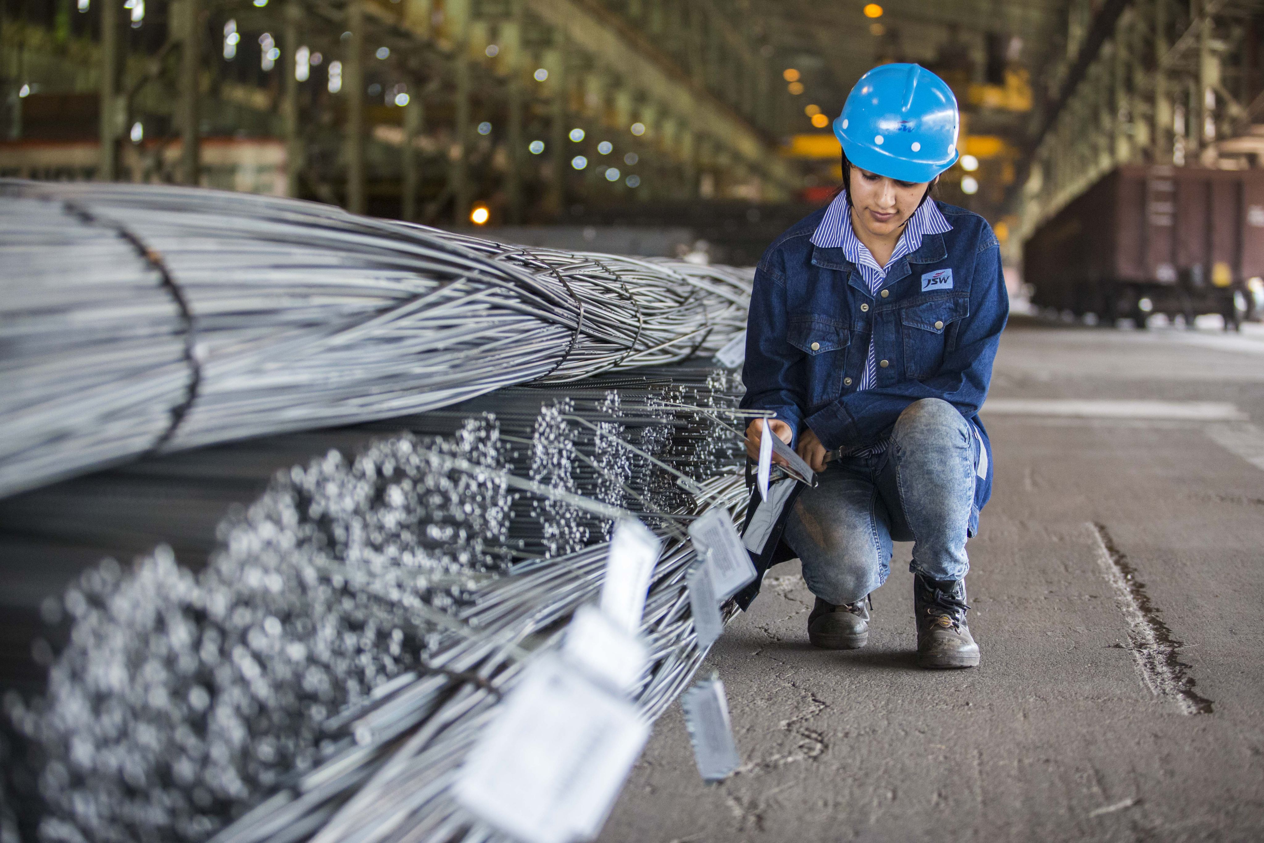 JSW Steel worker inspecting wire rods